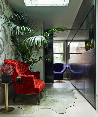 aquarium in a hallway with red chair and large plant