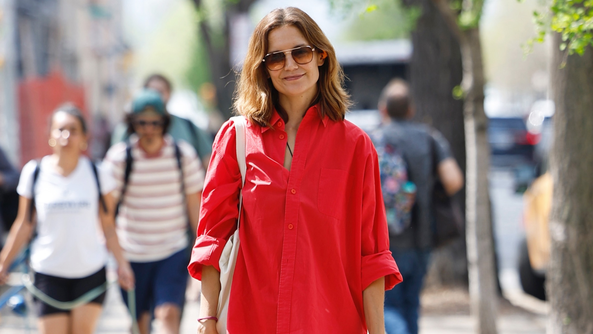 Katie Holmes wearing a red button-down, blue lace-trimmed dress, and black glove flats in NYC