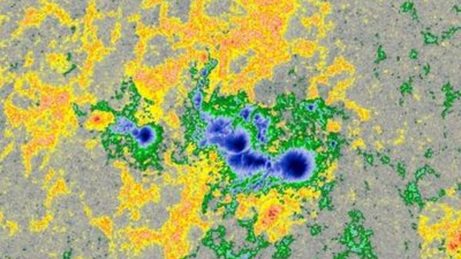 A multicolor image of a sunspot on the sun surrounded by invisible magnetic fields