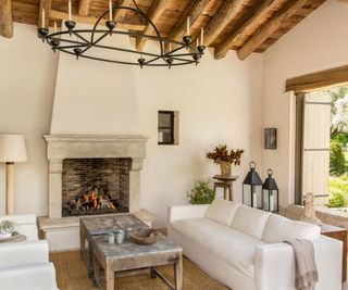 Living room with vaulted ceiling and white sofas around fireplace
