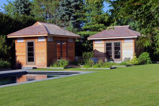 summerhouse ideas with two wooden structures next to each other by a pool