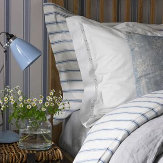 Blue stripe bedding in bedrooms with sidetable