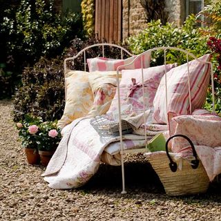 daybed in garden layered with quilts and cushions
