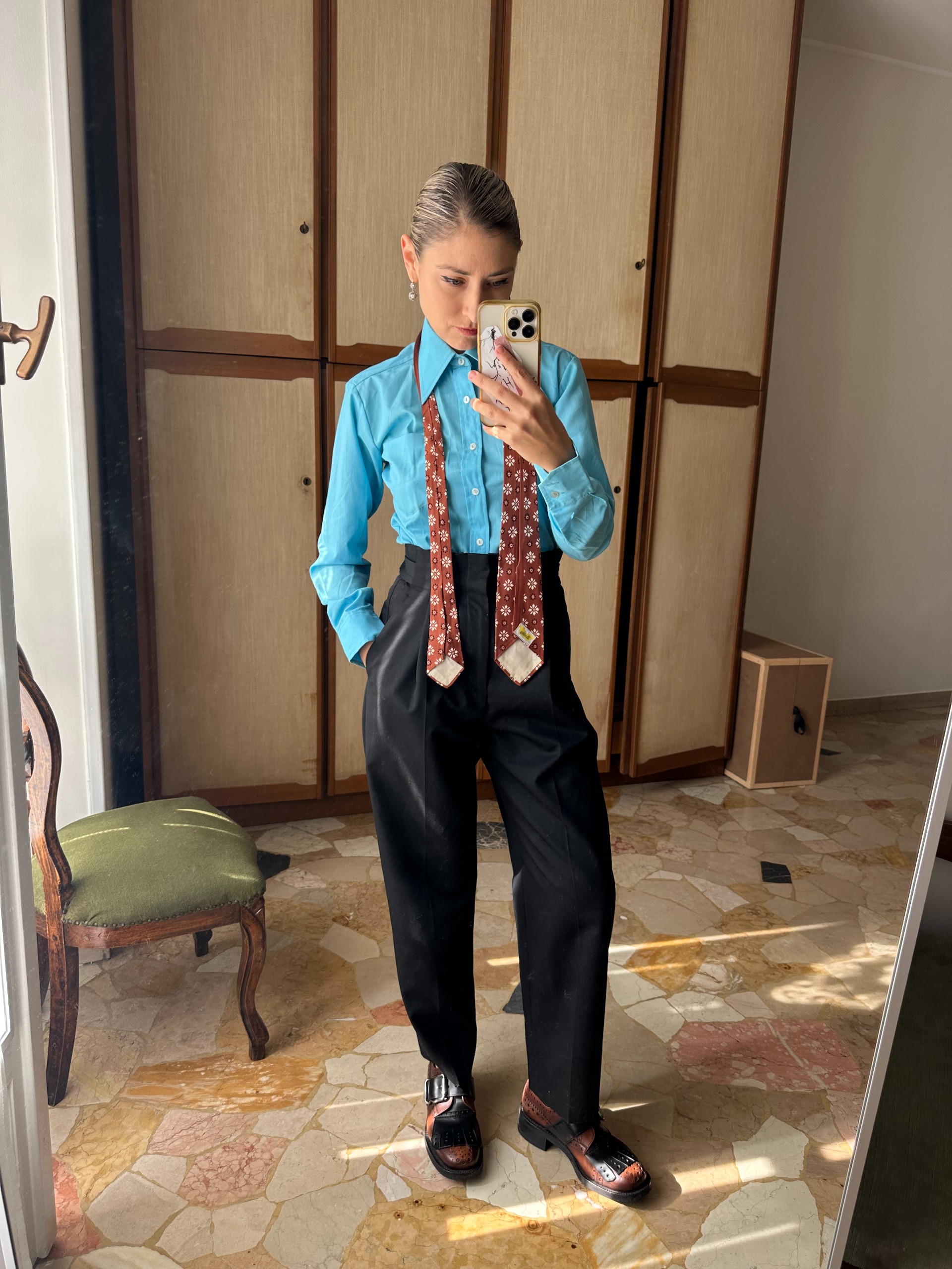 JENNY WALTON 2: Natalie Hammond Era's dressing 2026. She is wearing a blue shirt, black high-waisted trousers, brown and black loafers and a red checked tie. This image was recently provided by Jenny.