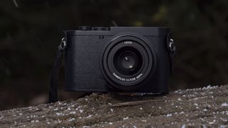 Leica Q3 Monochrom compact camera outside on a snow-dusted log