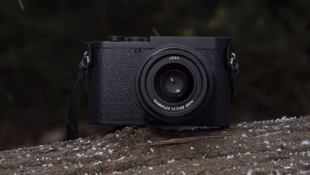 Leica Q3 Monochrom compact camera outside on a snow-dusted log