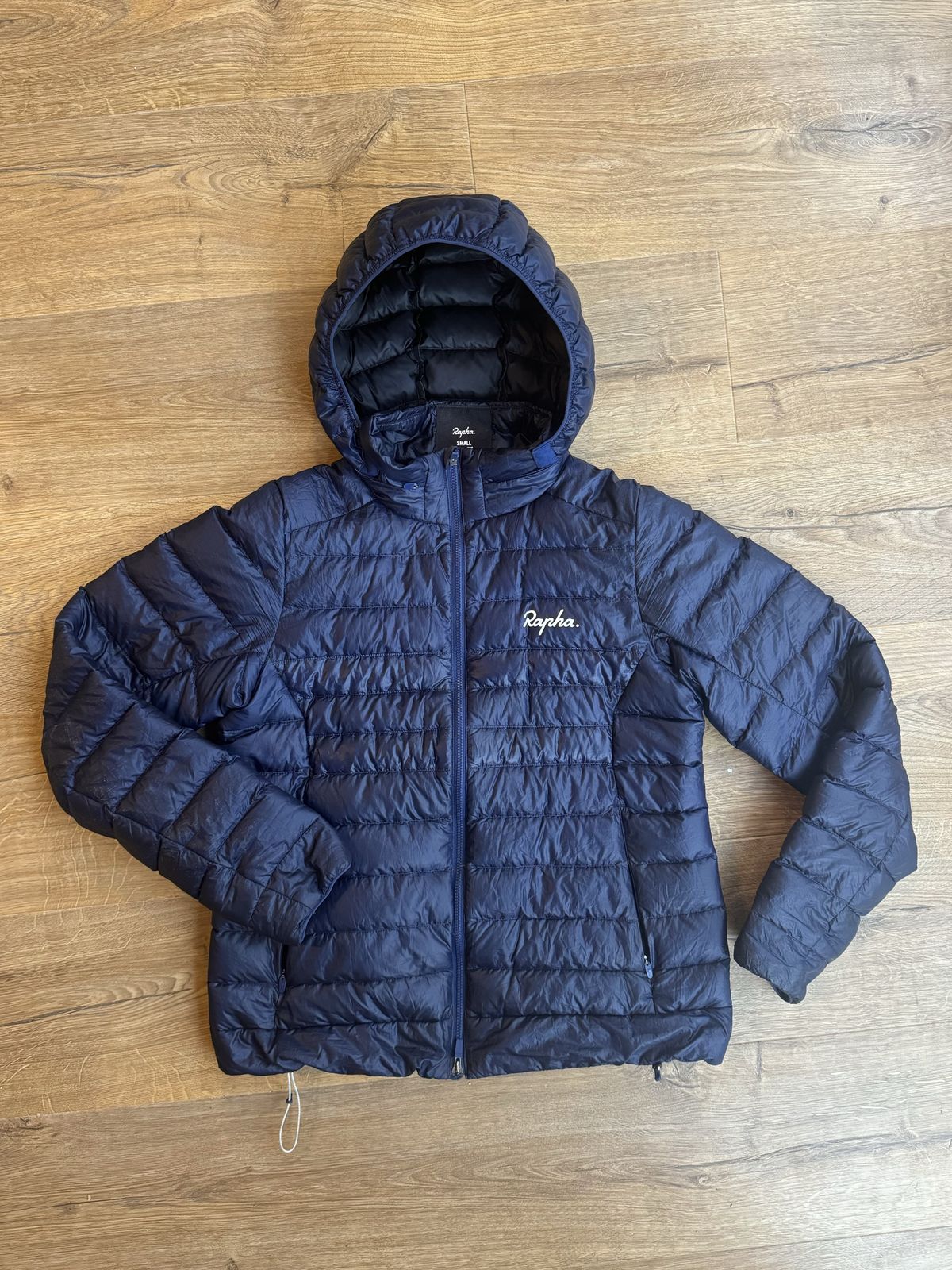 Flay lay blue jacket with hood up and one arm folded