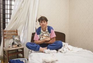 olympic athlete sits in bed with stuffed animal