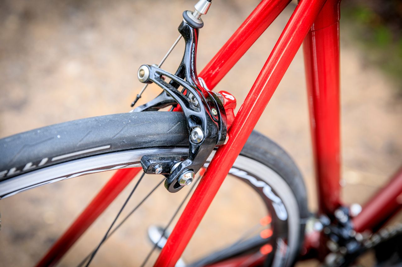 a Campagnolo Caliper rim brake mounted on a read steel frame bike