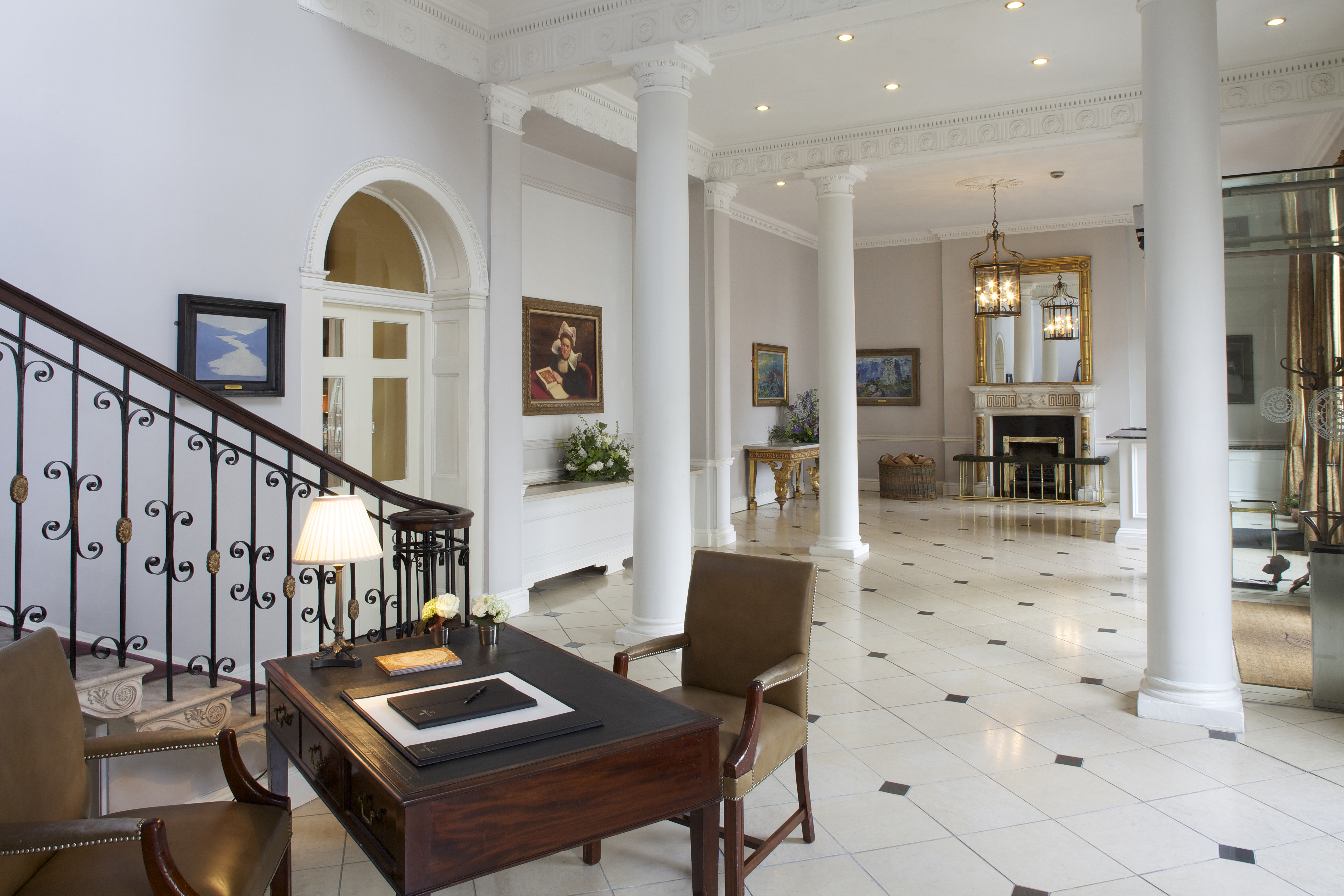 The lobby of The Merrion Hotel in Dublin, with white columns and a black ironwork staircase