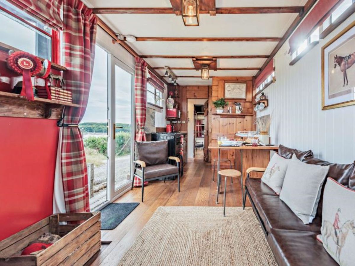 The interiors of the caravan shows wooden flooring and beams on the roof