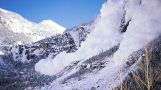 在阳光明媚的日子里，雪崩发生在山脉上