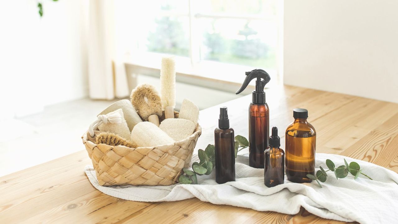 Cleaning bottles on a line on a table beside a basket of clothes and brushes