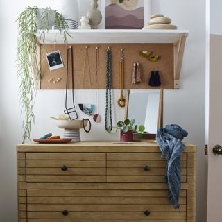 white wall with shelf and wooden drawers