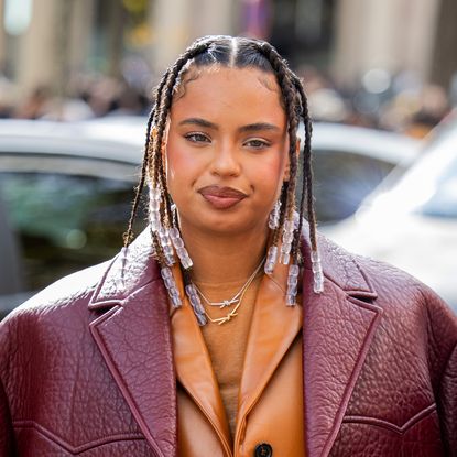 Paola Lacatelli wears burgundy jacket, brown bag, skirt, jacket outside Miu Miu during the Womenswear Spring/Summer 2024 as part of Paris Fashion Week on October 03, 2023 in Paris, France