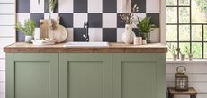 green kitchen cabinets with black and white checkerboard backsplash