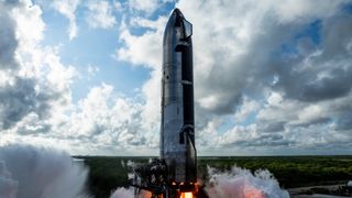 a silver rocket conducts an engine test with a cloudy sky in the background