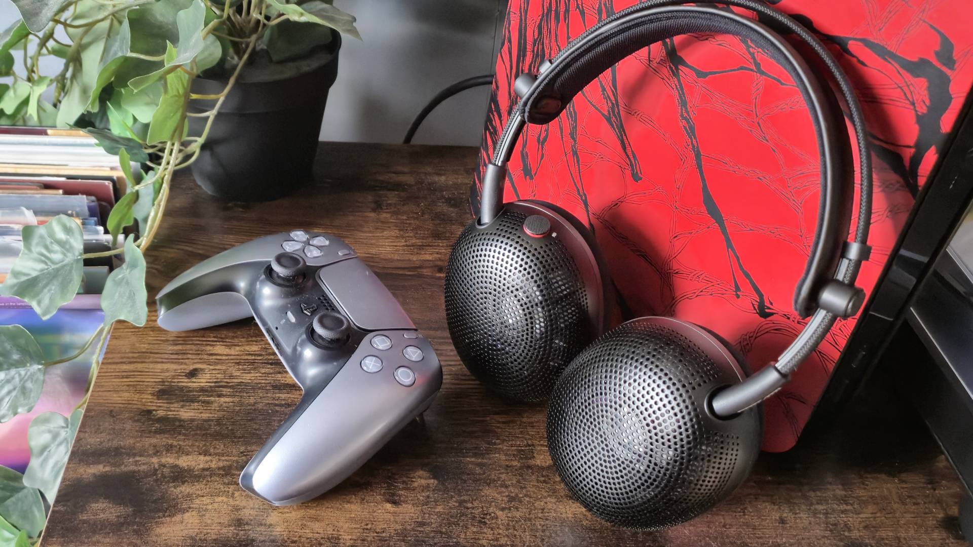Photo of the Sony Inzone H6 Air headset sitting next to a silver PS5 DualSense controller.