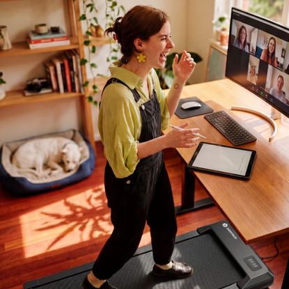 Woman working on meeting call while on walking pad at her standing desk