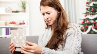 Disappointed woman opening Christmas gift