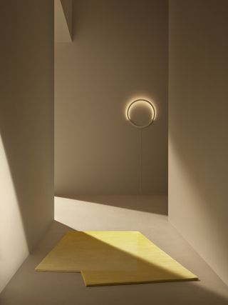 A corridor with a circular backlit wall lamp