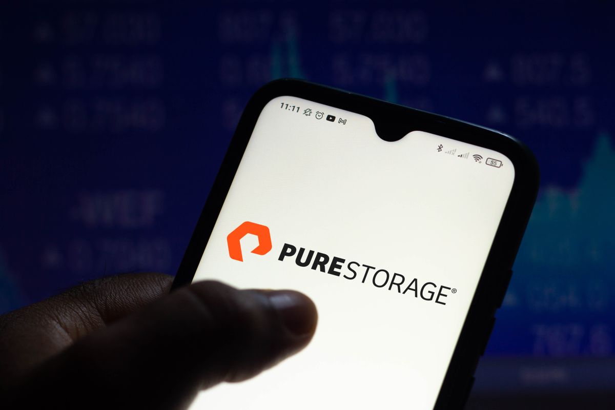 Pure Storage logo on a smartphone held in someone&#039;s hand, set against a dark blue background