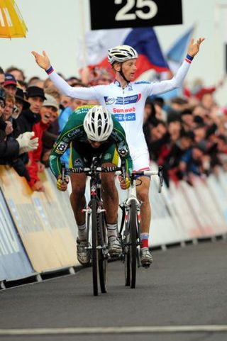 Sven Nys races to victory while Kevin Pauwels raises his arms in protest