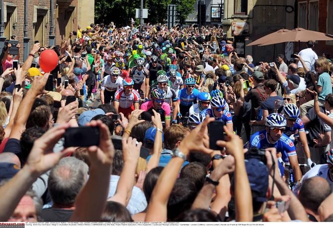 Fans try to capture the moment the Tour de France passed by