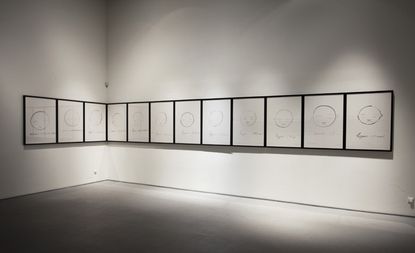 White wall with a row of different face drawings in black frames