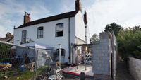 white house with side extension partly built