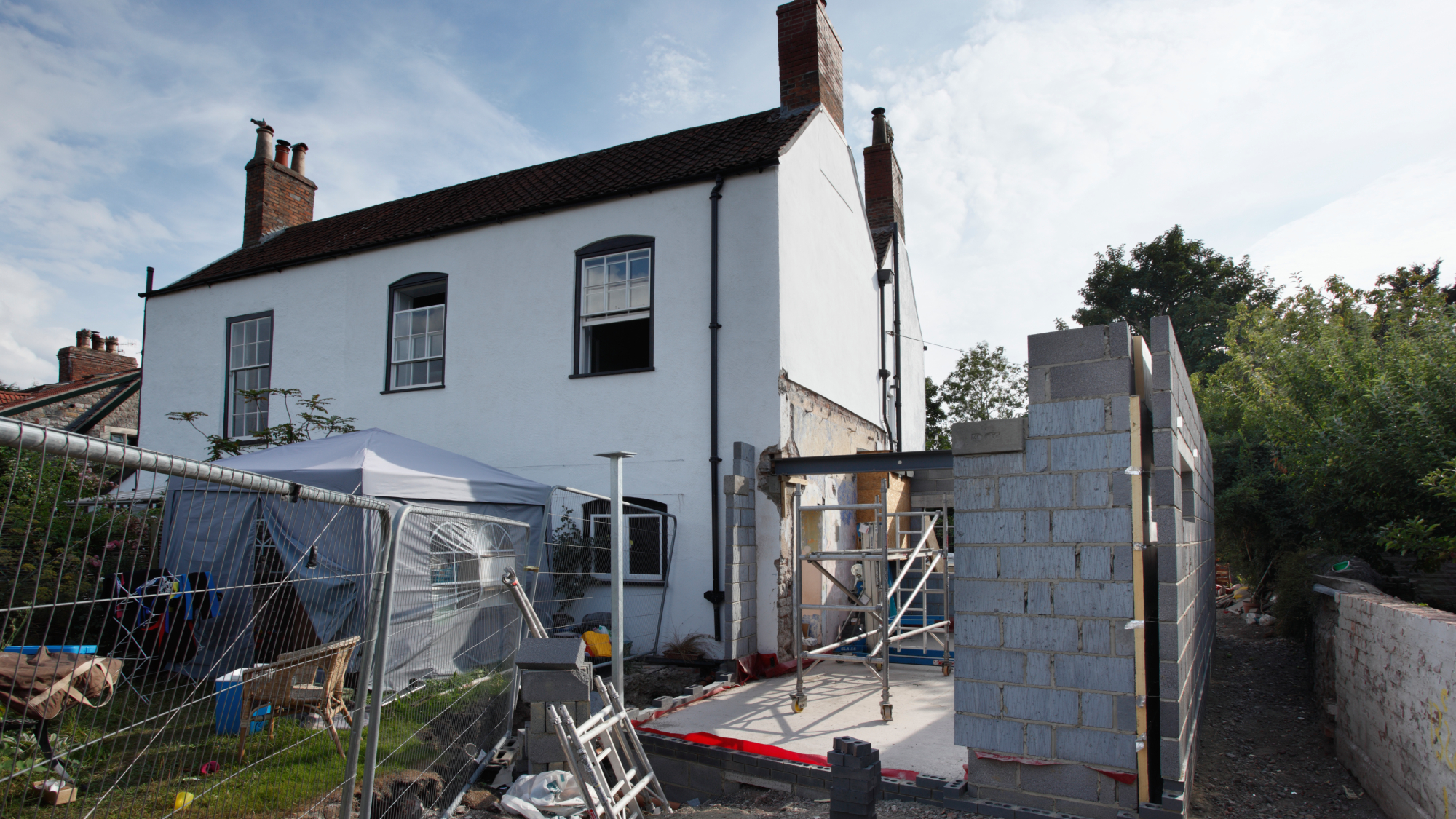 white house with side extension partly built