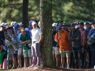 Rory McIlroy out of position hitting a shot at the base of a tree at Augusta National
