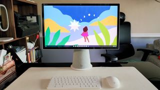 HP Chromebase All-in-One 22 on a standing desk next to its keybooard and mouse