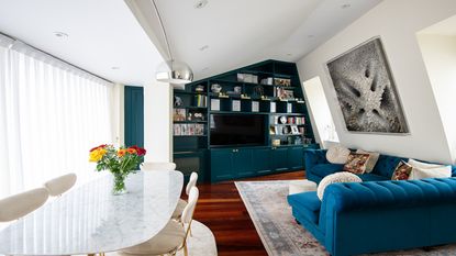 living room with blue bespoke shelving unit with books and a tv