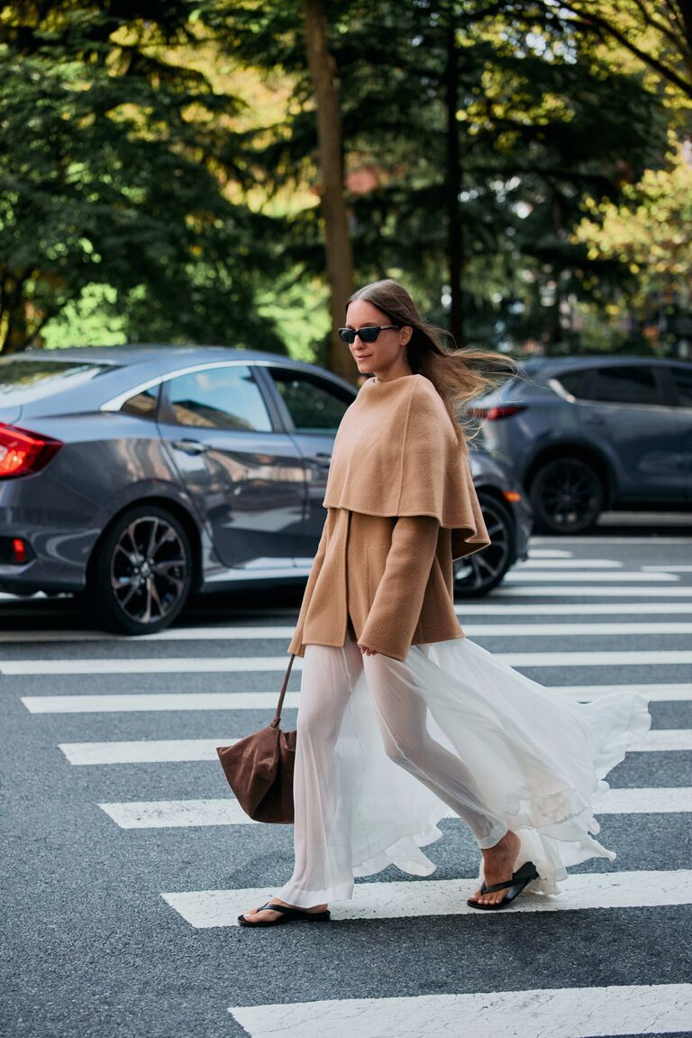 Woman in sheet skirt and a cape coat