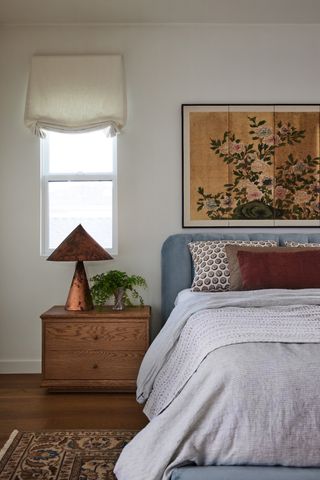 cozy modern bedroom with art, roman blinds and rug