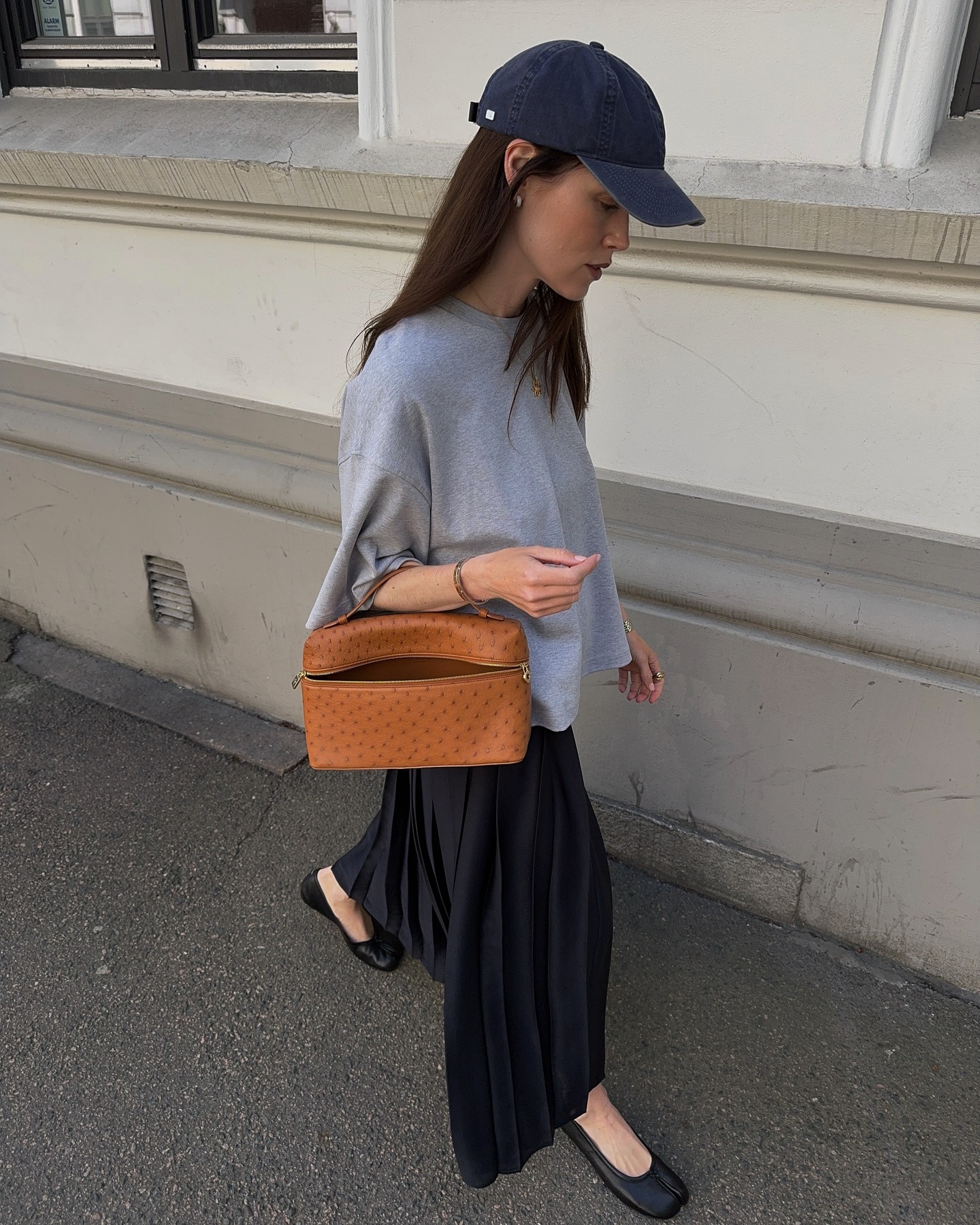 European influencer wearing a grey T-shirt, black midi skirt, and black ballet flats