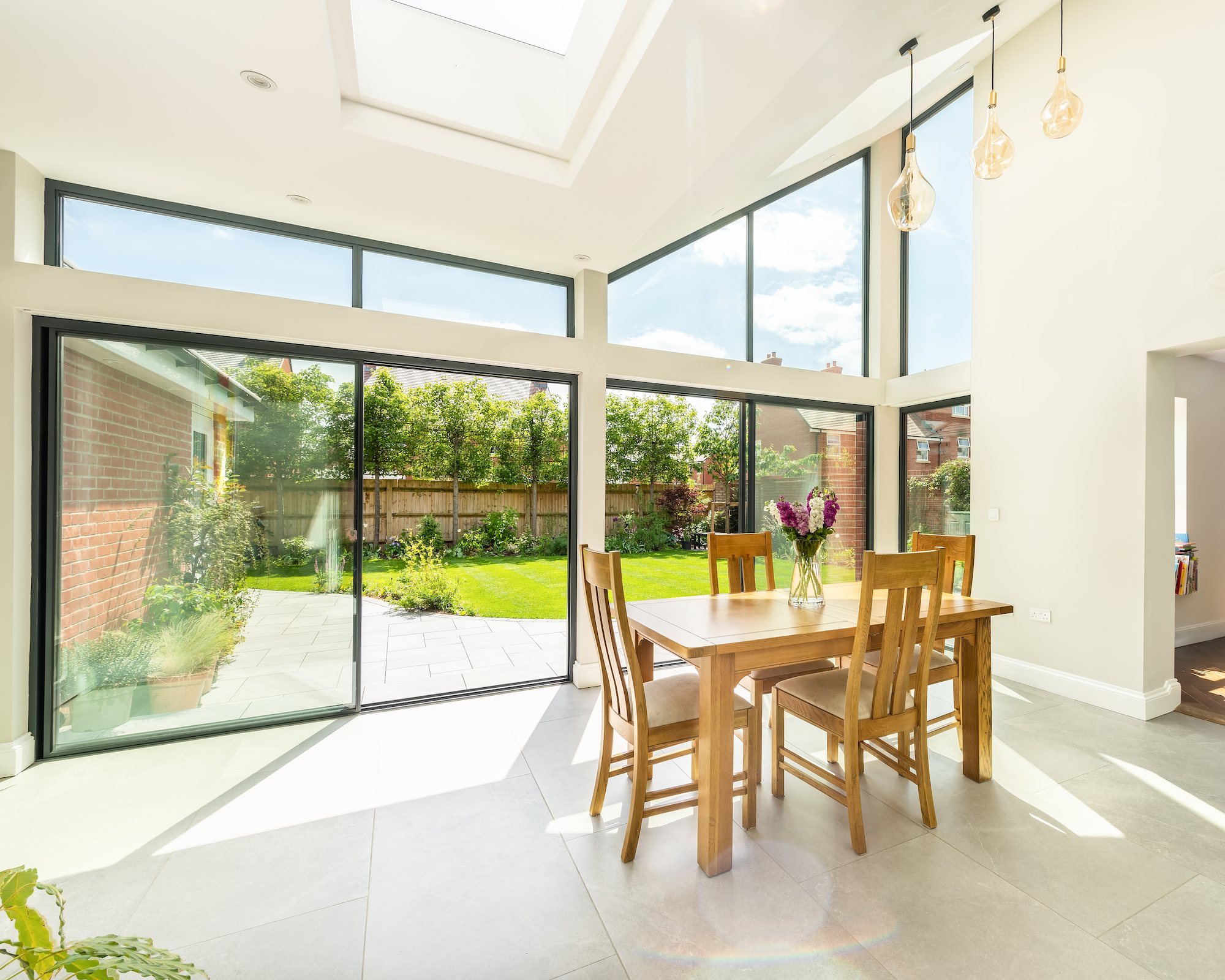 Dining extension with glazed doors and windows and view to terrace and lawn