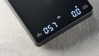 a black square coffee scale by Maestri House with a timer and a rechargeable battery