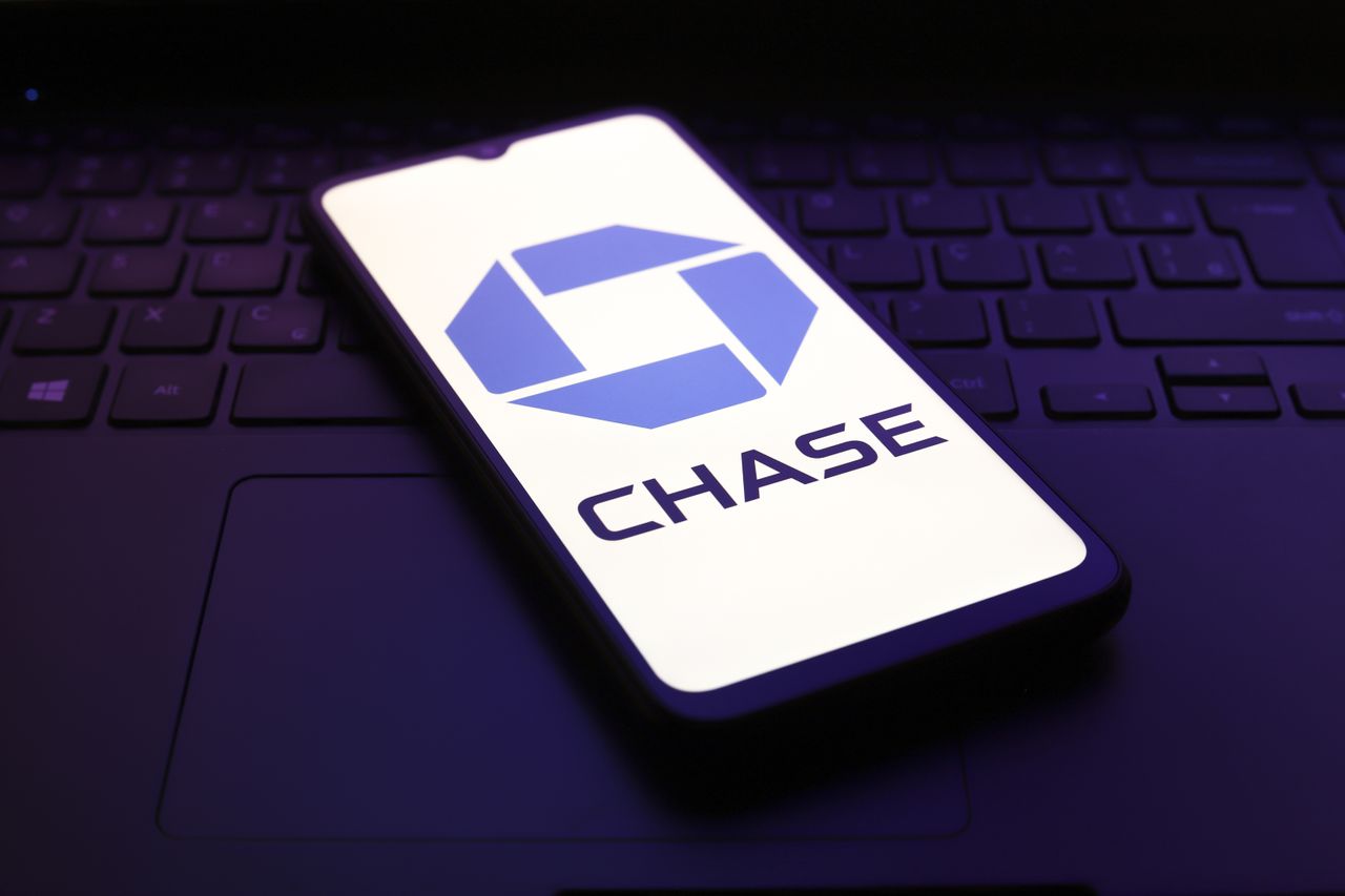 Chase bank logo on mobile phone screen, which is on top of laptop keyboard