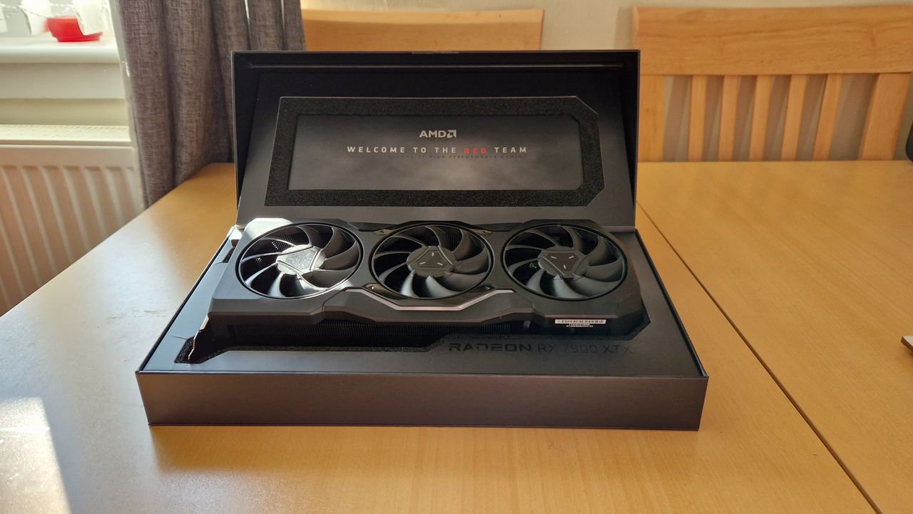 AMD Radeon RX 7900 XTX review image inside the box, which has a "welcome to the red team" message on the open lid