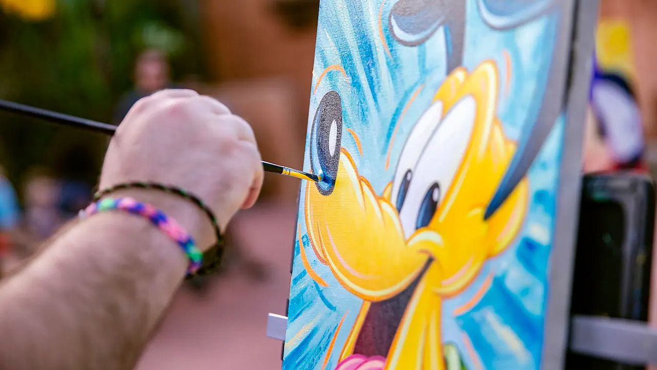 artist paining Pluto at Epcot International Festival of the Arts