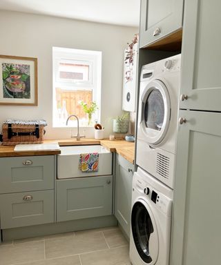 garage converted into utility room with sink, washing machine, tumble dryer and cupboards