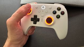 A photo of a hand holding an 8BitDo Ultimate 2 Wireless game controller