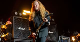 Dave mustaine grimaces as he plays a riff live during a Megadeth show.