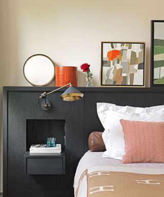 Built in headboard and storage in black with bed dressed in white and pink.
