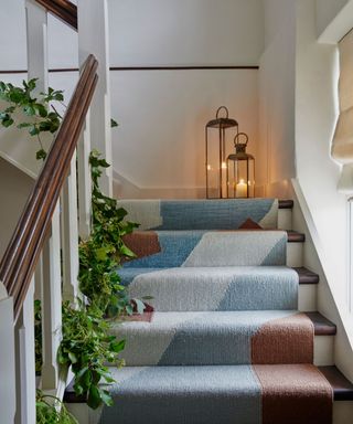 staircase with blue carpet runner and Christmas garland running up the edge