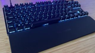 SteelSeries Apex Pro TKL Gen 3 keyboard on a wooden desk with wrist rest attached