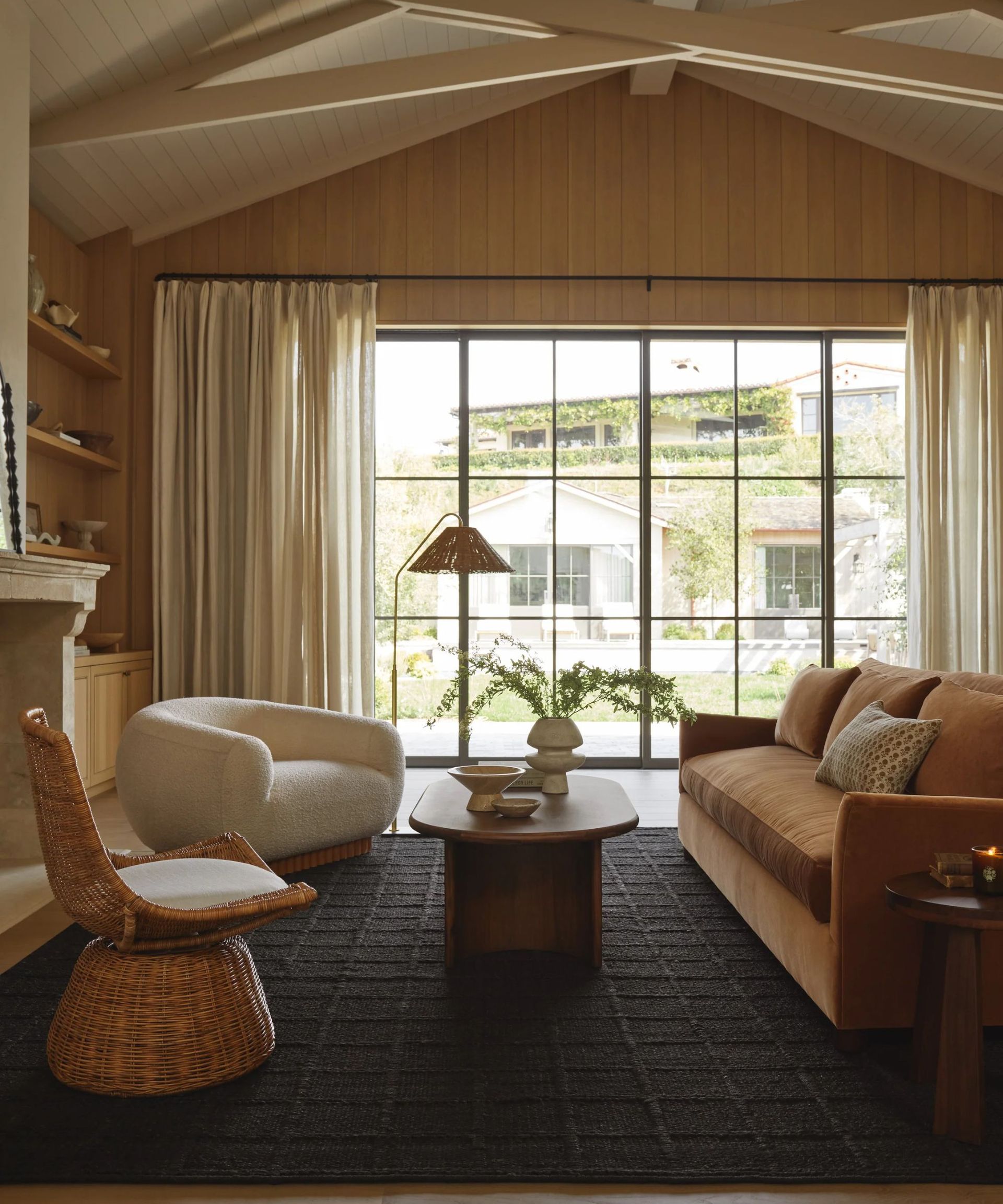 Neutral living room with wood panelled walls, dark room and large window
