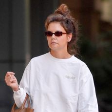 Katie Holmes walks in New York City wearing a messy bun and adidas sneakers